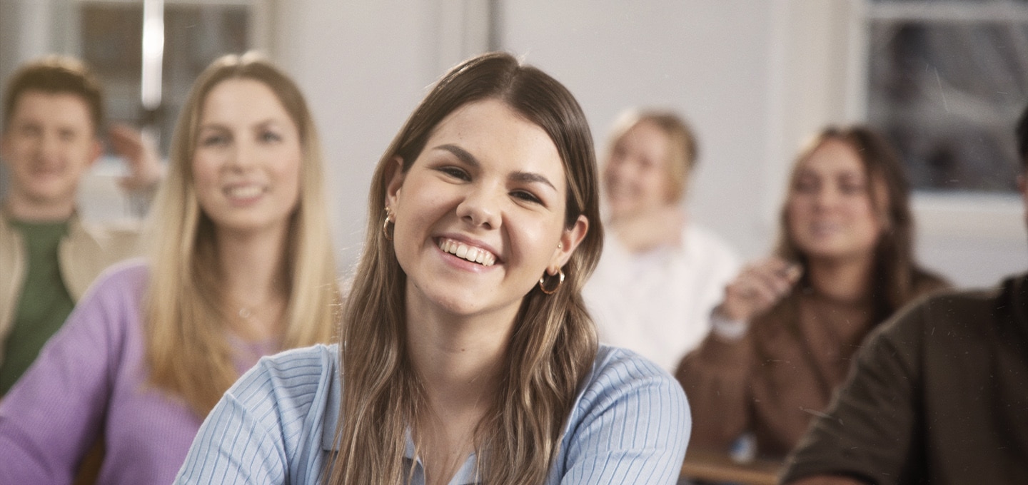 header_vz_studentin_vorlesung_lächeln_klassenraum