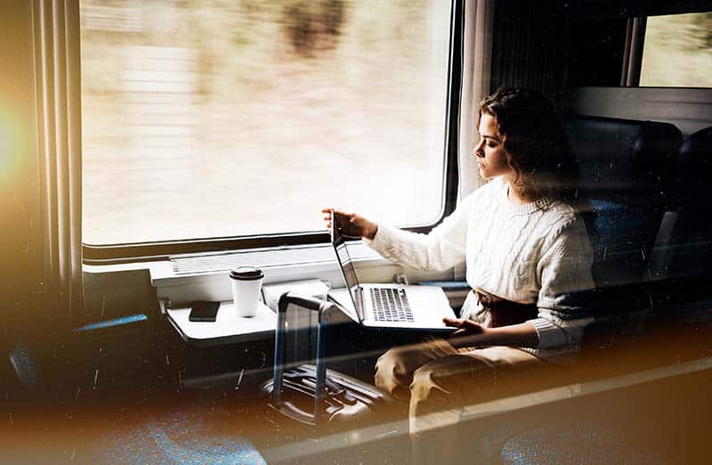 Mobilität - das Bild zeigt eine Person, die am Laptop arbeitet in der fahrenden Bahn