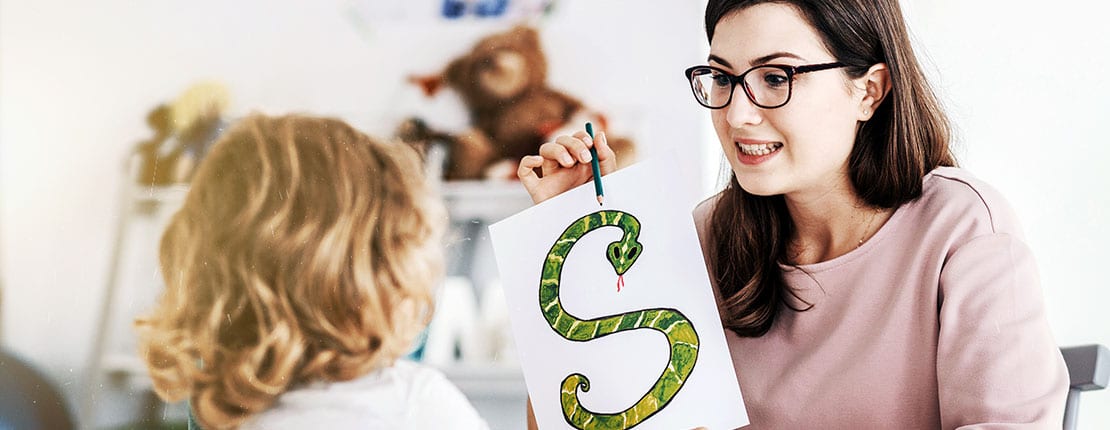 Frau zeigt einem Kind ein Bild einer Schlange